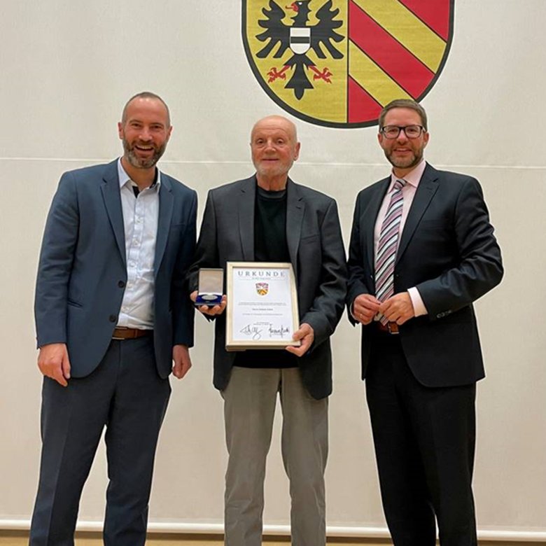 3 Männer bei Urkundenverleihung
