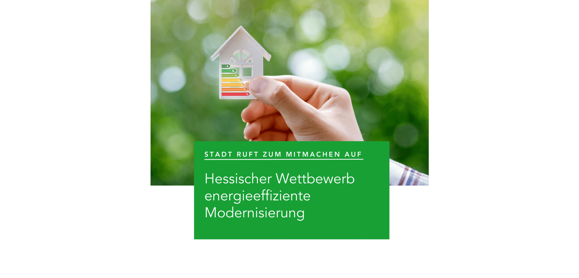 Hand hält kleine Hausschablone mit Energieeffizienzklassen