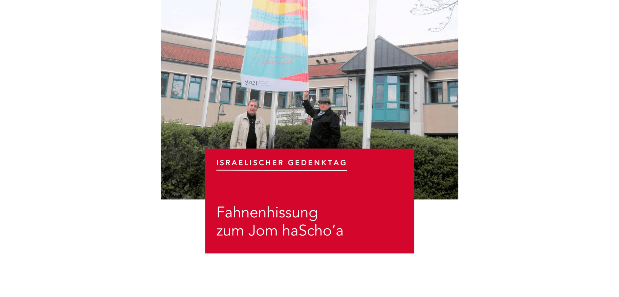 Zwei Herren unter einer Fahne vor dem Rathaus