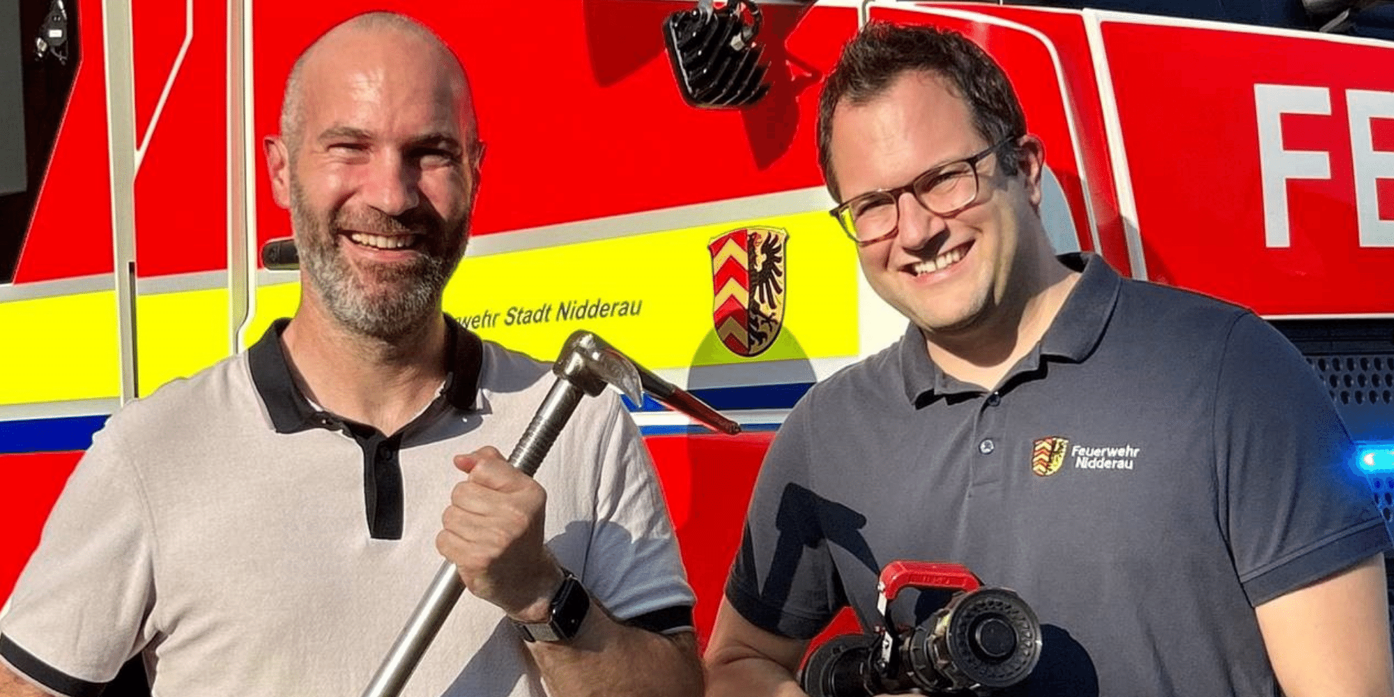 Zwei Männer vor einem Feuerwehrauto