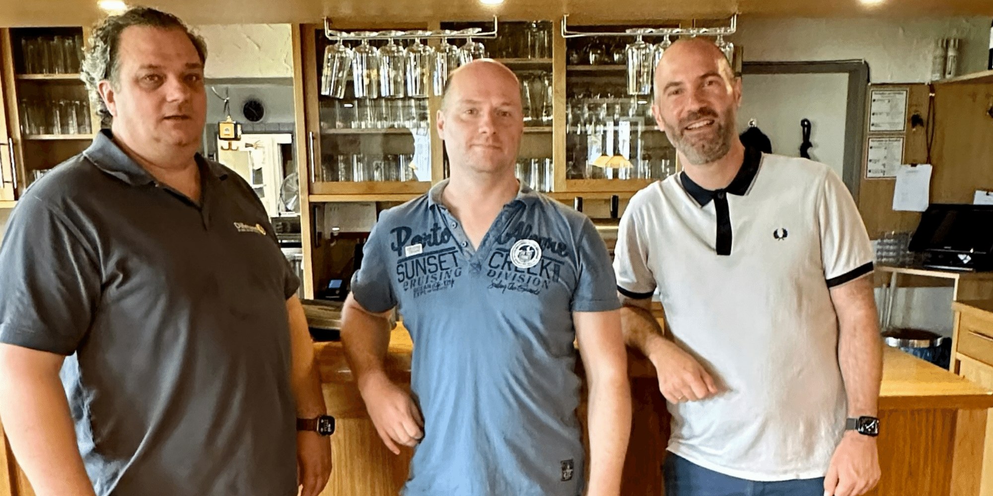 3 Männer stehend vor einer Theke