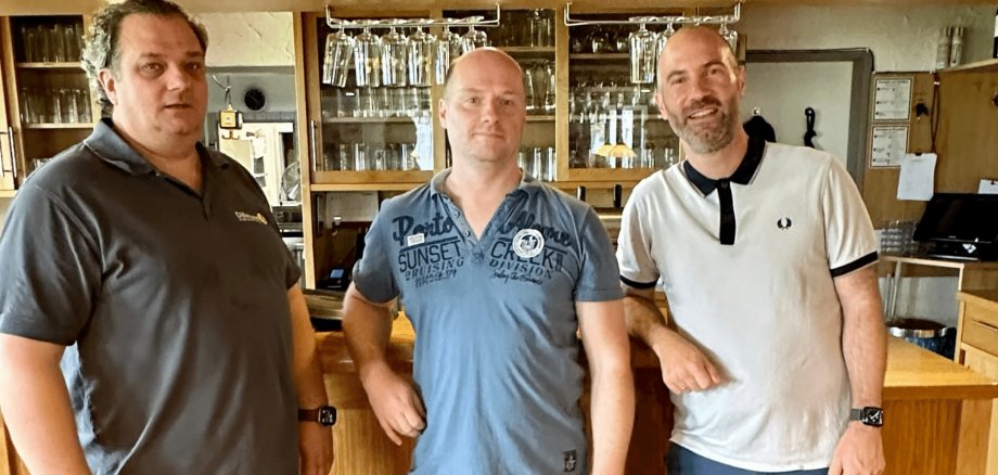 3 Männer stehend vor einer Theke