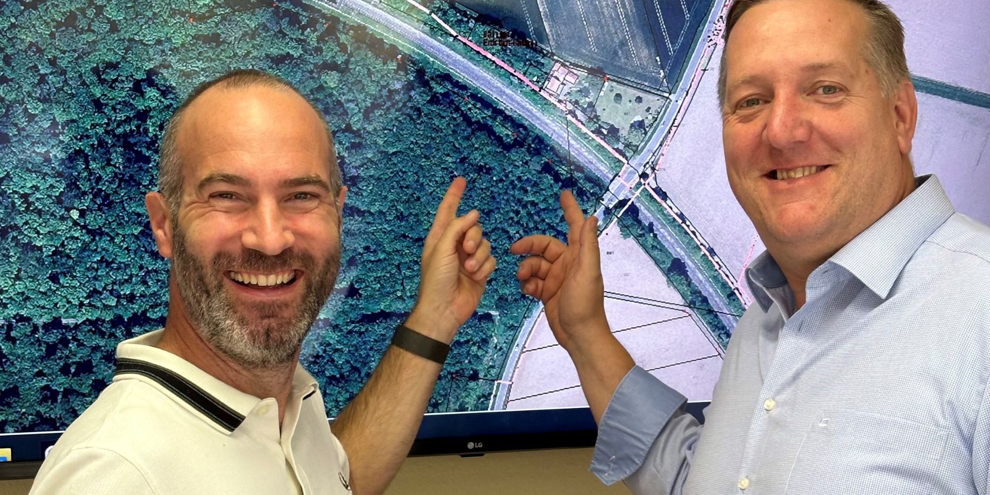 Bürgermeister Hahn und Bär zeigen auf Landkarte