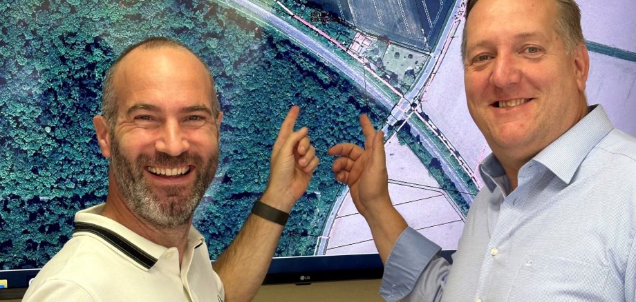 Bürgermeister Hahn und Bär zeigen auf Landkarte