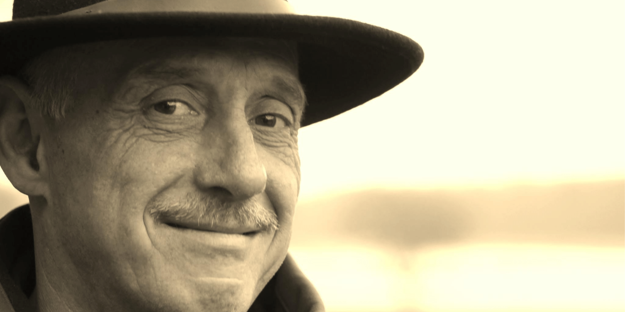 Mann mit Hut lächelnd