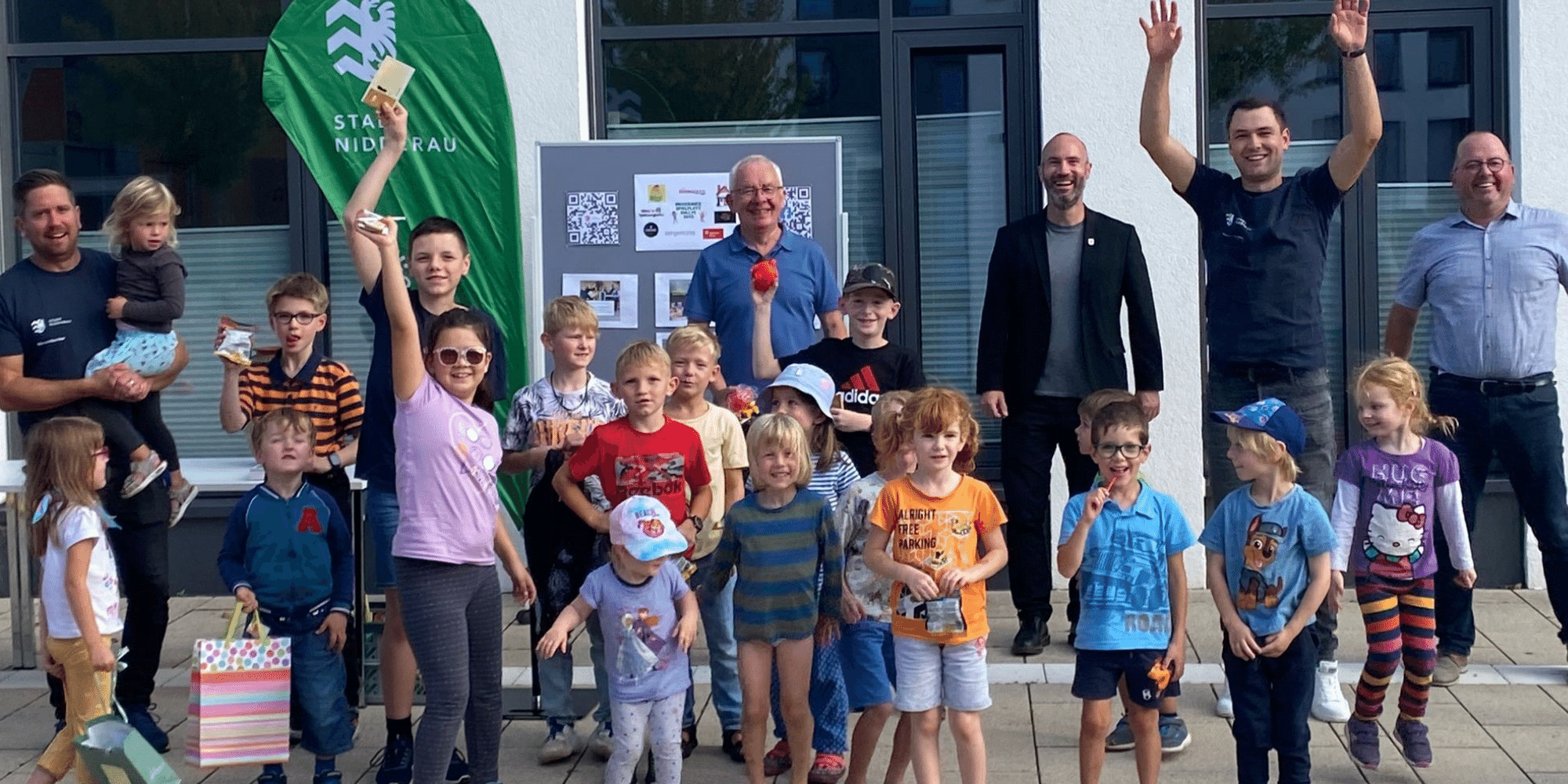 Gruppe von Kindern und Erwachsene im Hintergrund lächelnd