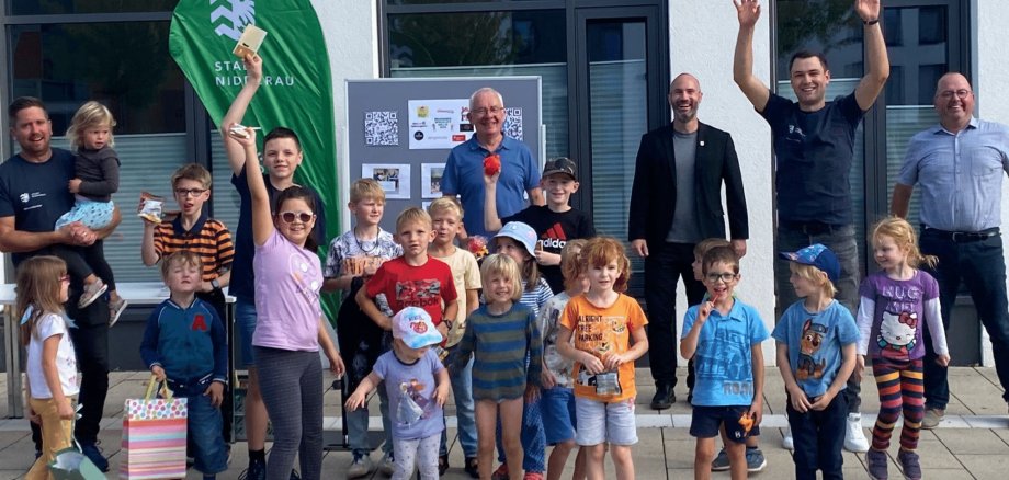 Gruppe von Kindern und Erwachsene im Hintergrund lächelnd