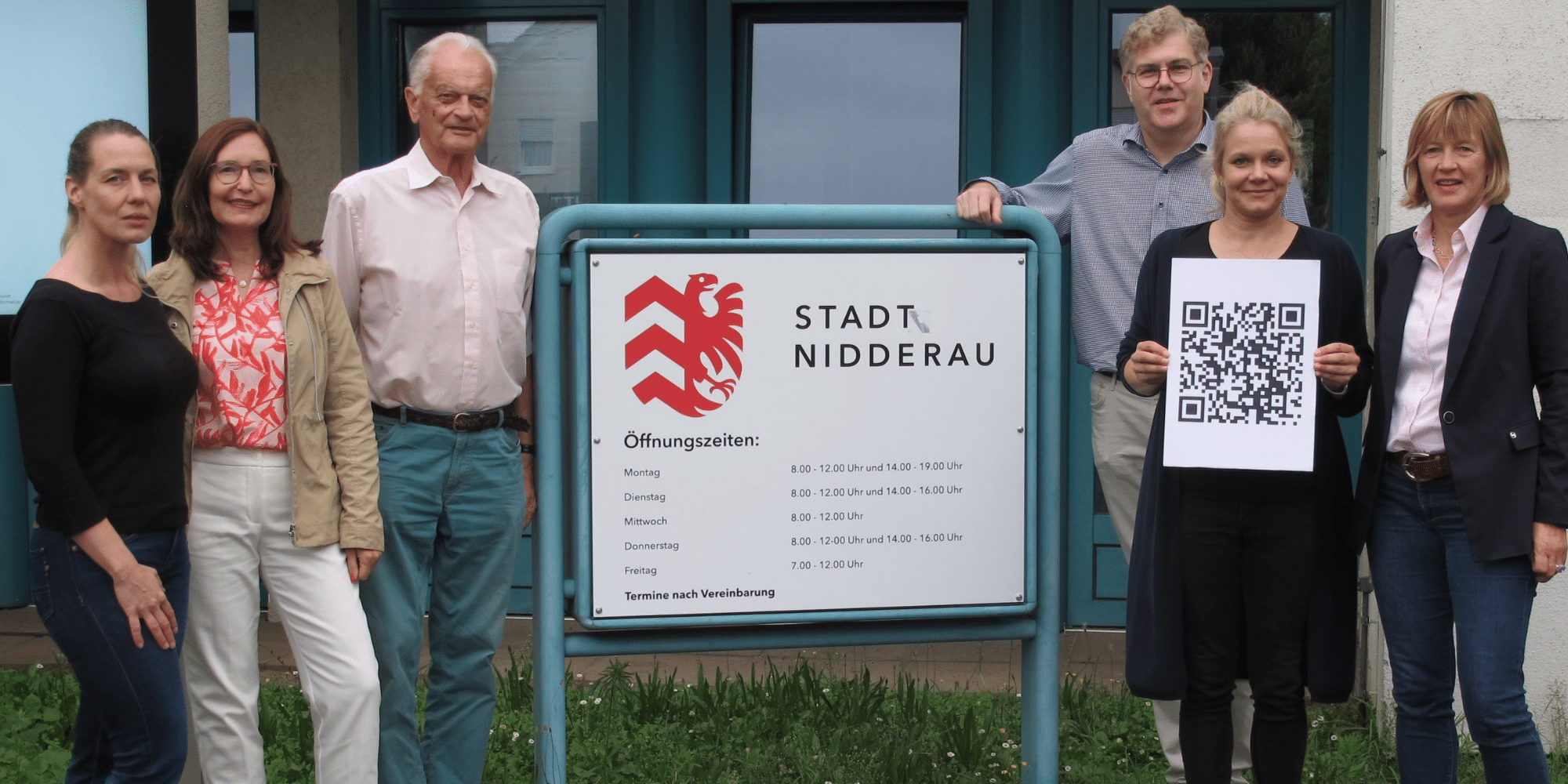 Mehrere Personen stehend vor dem Eingang des Rathauses