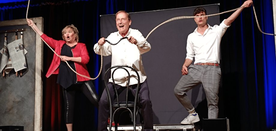 2 Männer und 1 Frau stehend auf einer Bühne