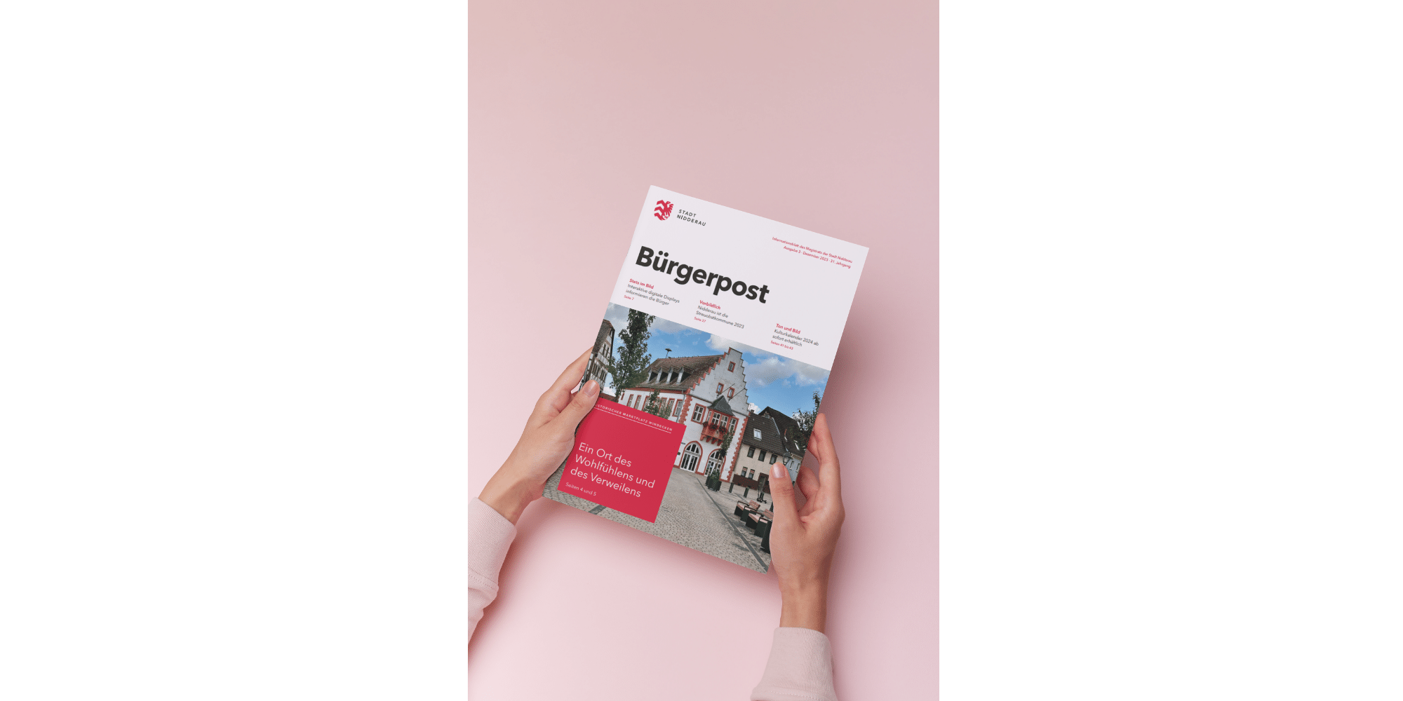 Magazin gehalten von zwei Händen auf rosa Hintergrund