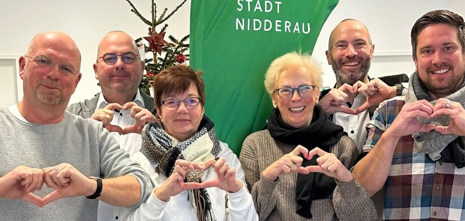6 Personen vor grüner Nidderau-Beachflag formen Herz mit der Hand