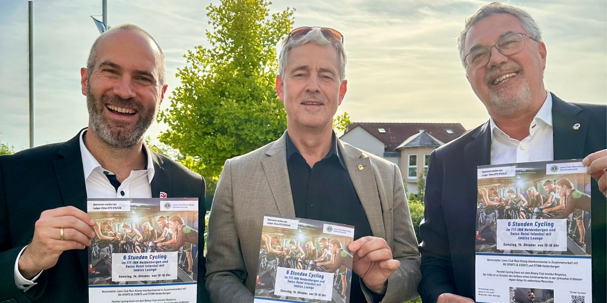 3 Männer halten Veranstaltungsplakate hoch