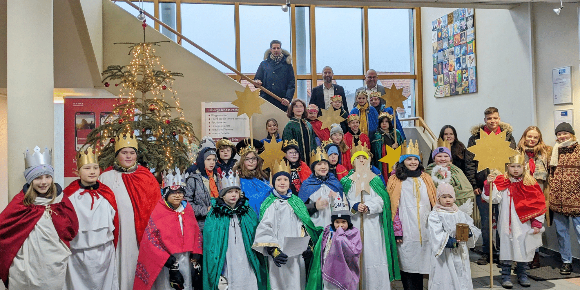 Kinder stehend mit langen Gewändern angezogen und zackigen Kronen auf dem Kopf