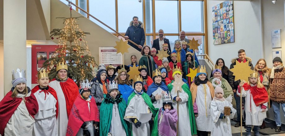 Kinder stehend mit langen Gewändern angezogen und zackigen Kronen auf dem Kopf