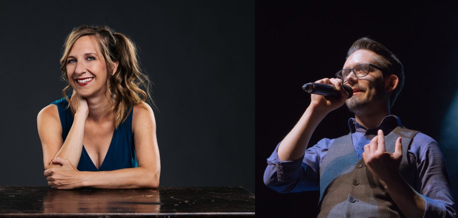 Frau sitzt lächelnd am Tisch, Mann spricht in ein Mikrofon