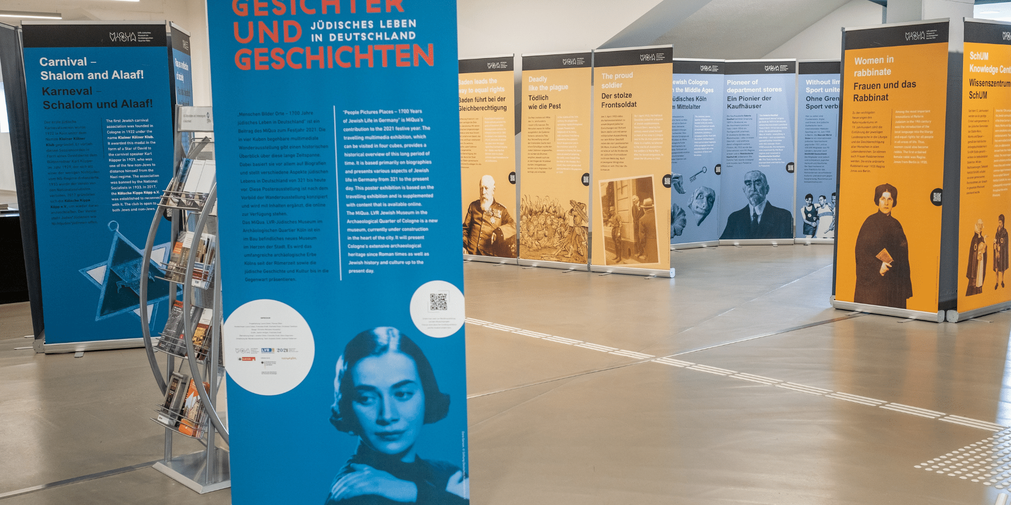 Bunte Posteraufsteller mit Gesichtern und Geschichten