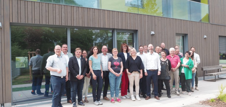 Mehrere Leute stehend vor der Außenfassade des neuen Kitagebäudes in Eichen