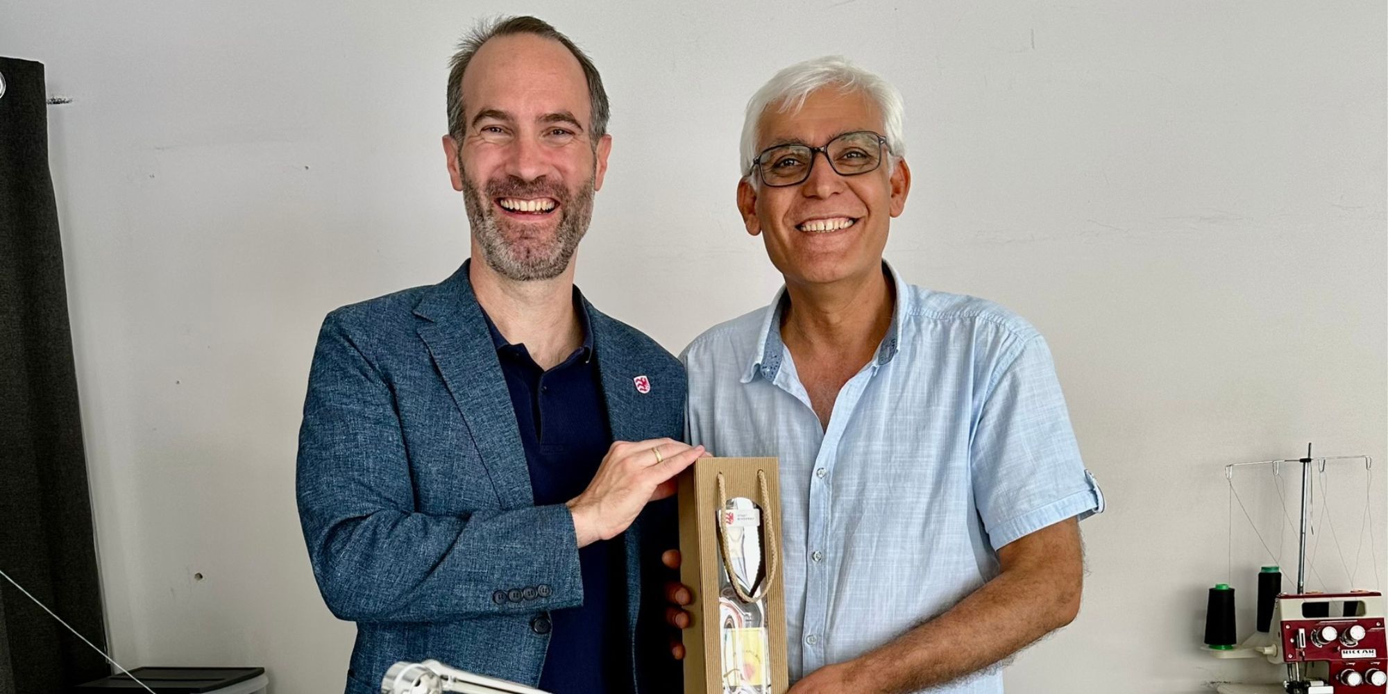 Mann überreicht eine Weinflasche als Präsent an einen anderen Mann