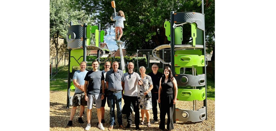 mehrere Personen stehend auf einem Spielplatz