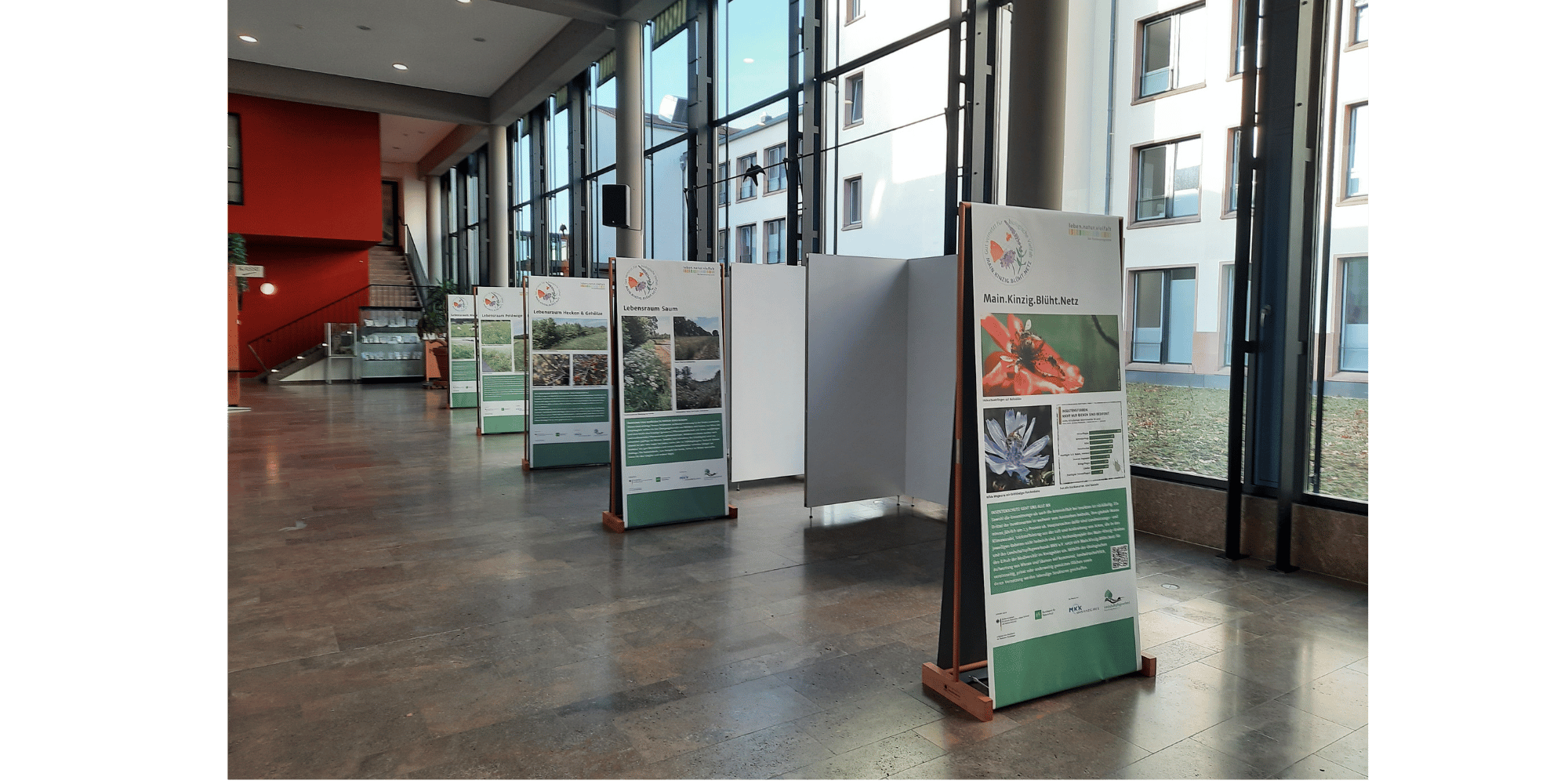 Raum mit großen  Fenstern und Plakaten