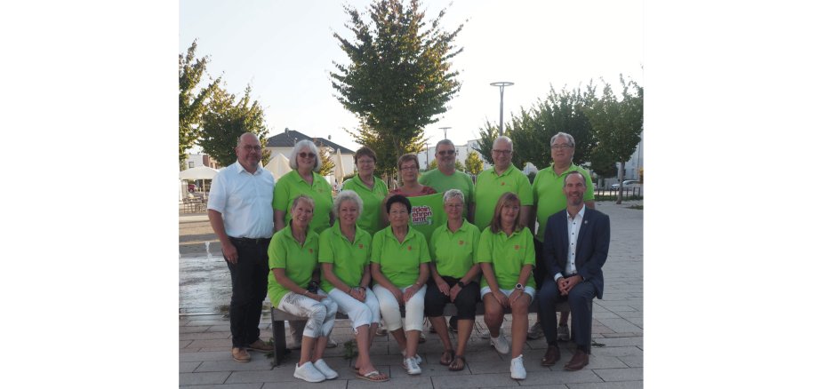 stehend 3 Frauen und 4 Männer, sitzend 5 Frauen und 1 Mann