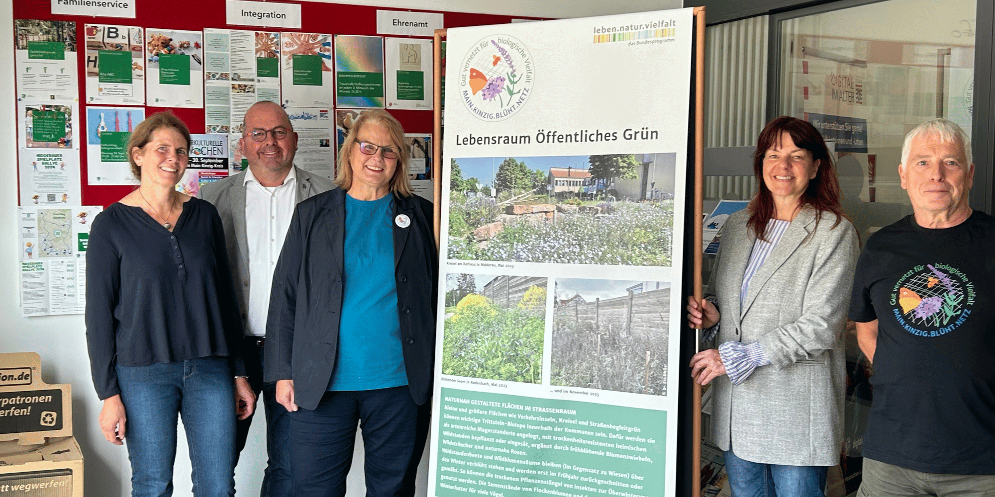 Mehrere Personen stehend vor Pinnwänden mit Informationen zum Thema der Ausstellung