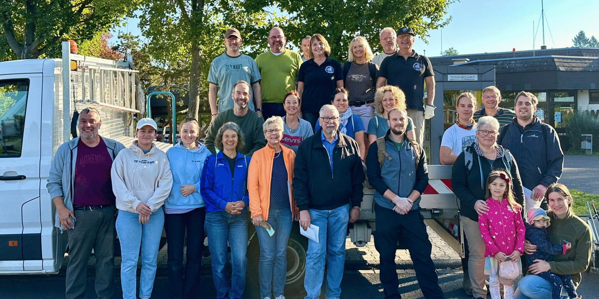 Mehrere Personen stehend vor einem Transportwagen