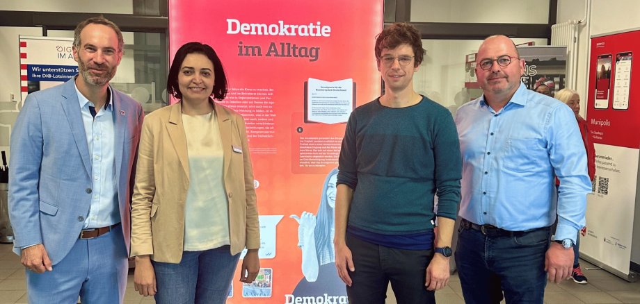 2024-10-10_Vortrag zu Demokratie und Rechtsextremismus 3 Männer und 1 Frau stehend vor einem Banner für eine Ausstellung