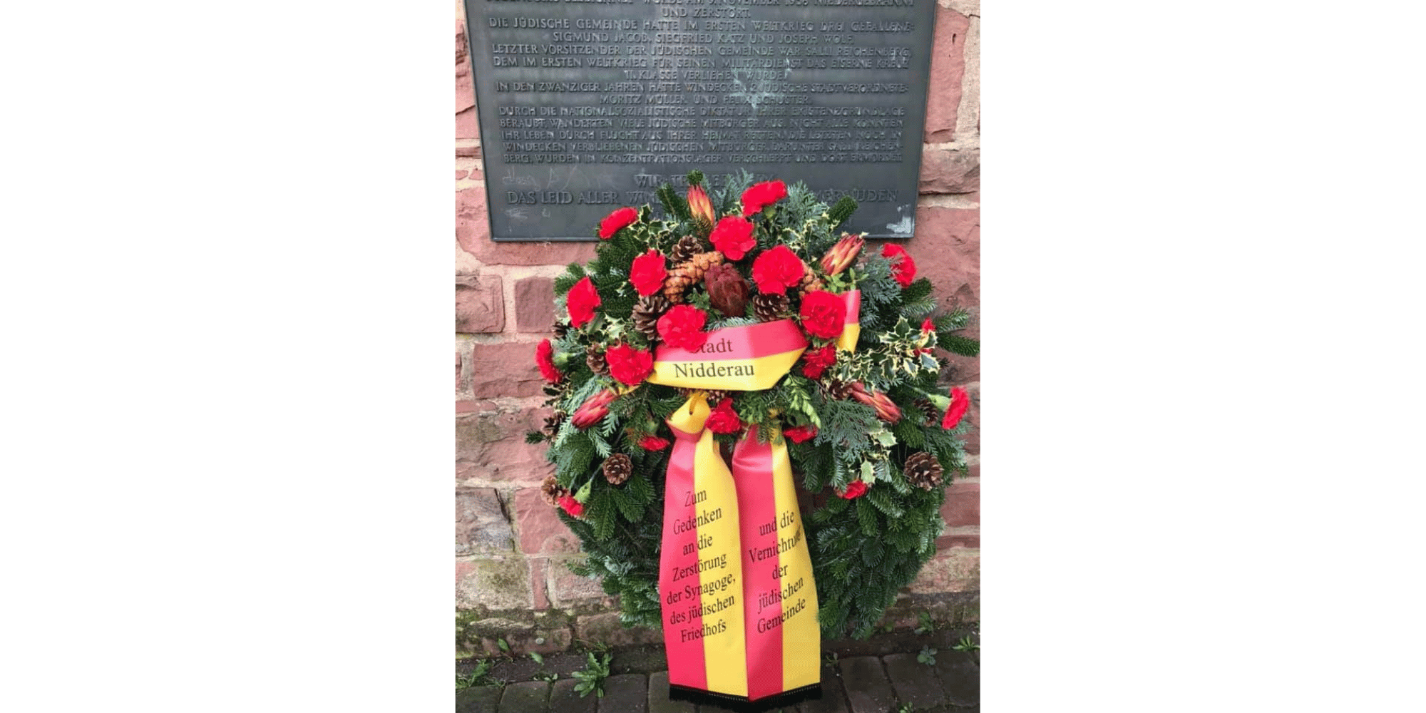 Kranz vor einer Gedenktafel