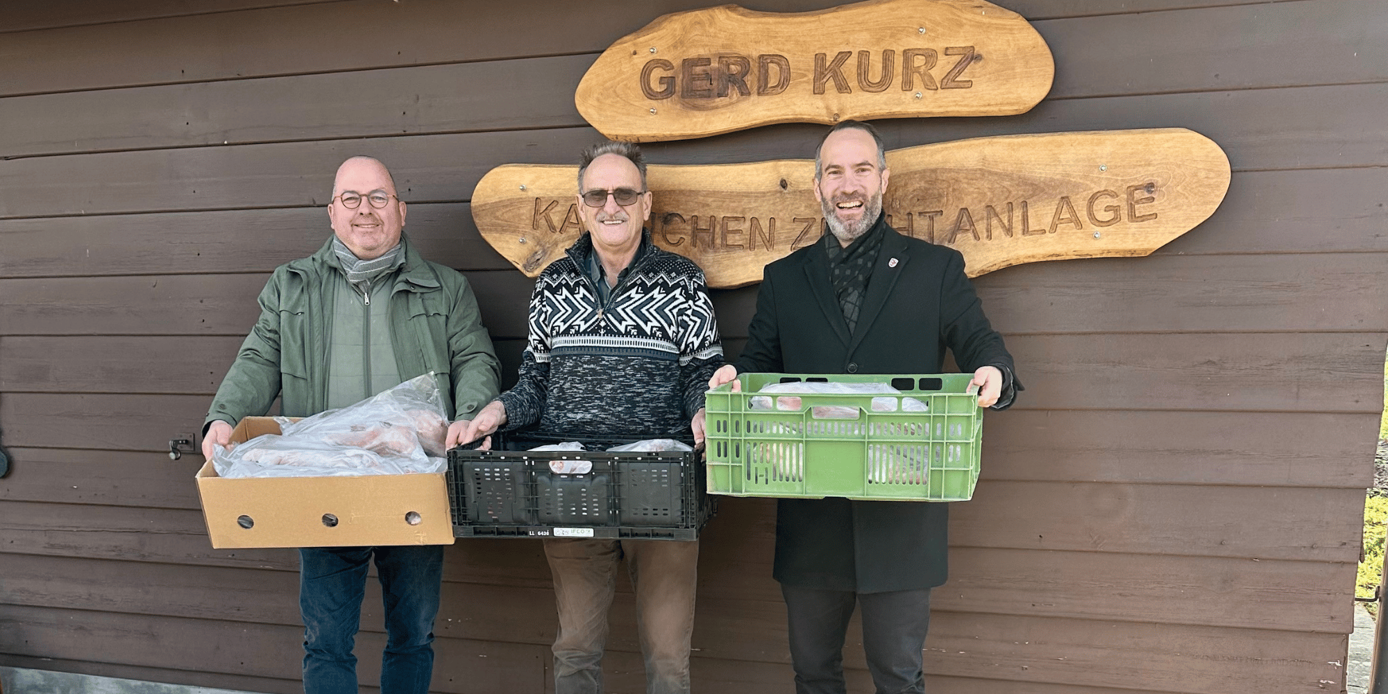 Drei Männer stehend mit je einer Kiste in der Hand