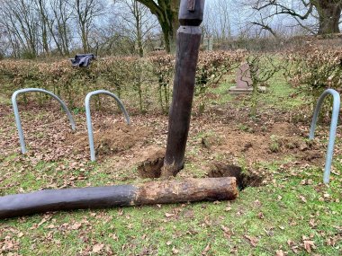 am Boden liegender Holzpfahl auf einem Feld
