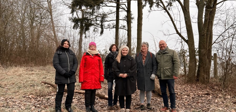 Sechs Personen stehend im Wald im Winter
