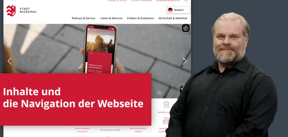 Mann in schwarzem Hemd stehend vor einem Hintergrundbild der Startseite der Homepage der Stadt Nidderau