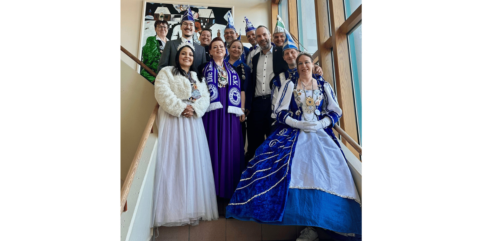 Mehrere Personen als Prinzenpaar verkleidet auf einer Treppe im Rathaus stehend