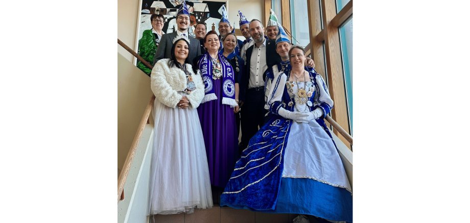 Mehrere Personen als Prinzenpaar verkleidet auf einer Treppe im Rathaus stehend