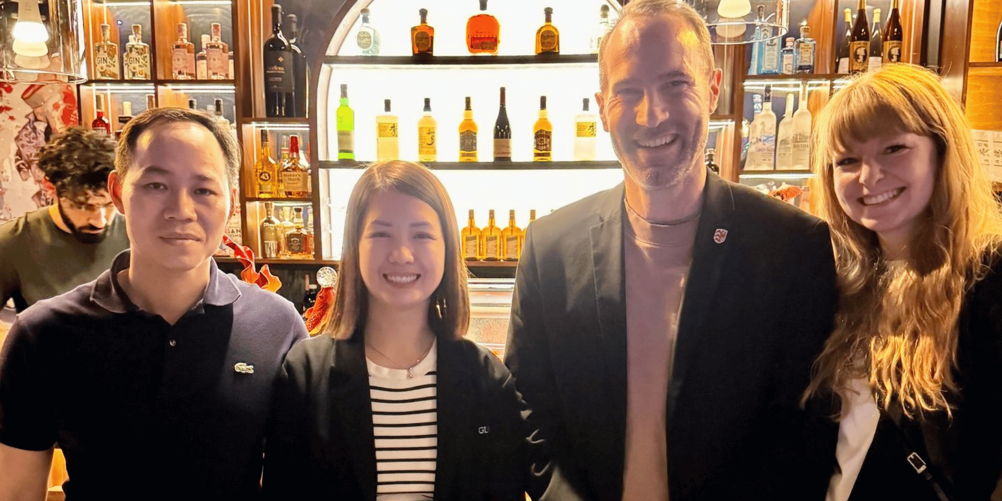 Zwei Frauen und zwei Männer stehend in einem Lokal