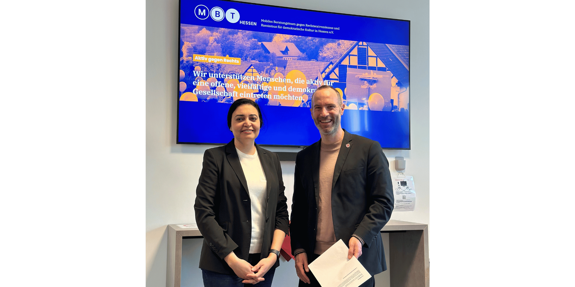 Ein Mann und eine Frau stehend vor einer Leinwand