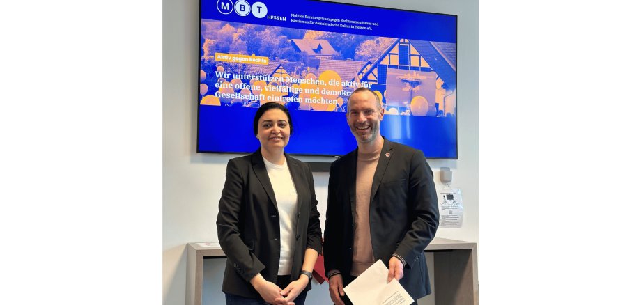 Ein Mann und eine Frau stehend vor einer Leinwand