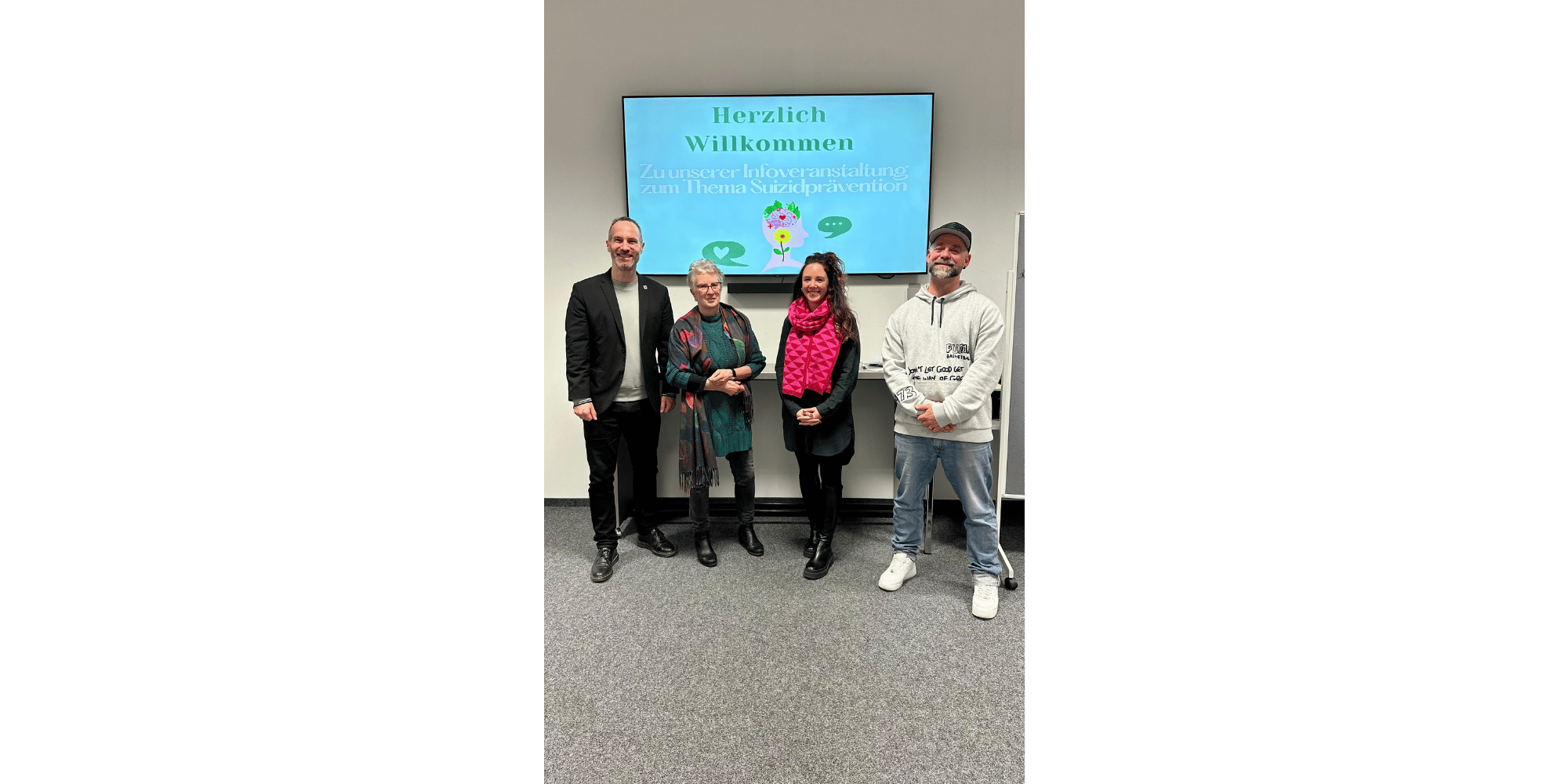 Zwei Männer und zwei Frauen stehend vor einem blauem Bildschirm