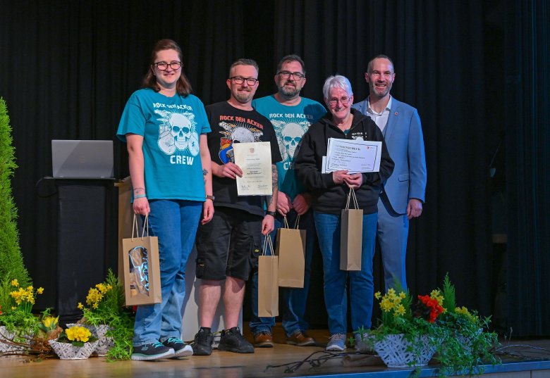 5 Personen stehend auf einer schwarzen Bühne