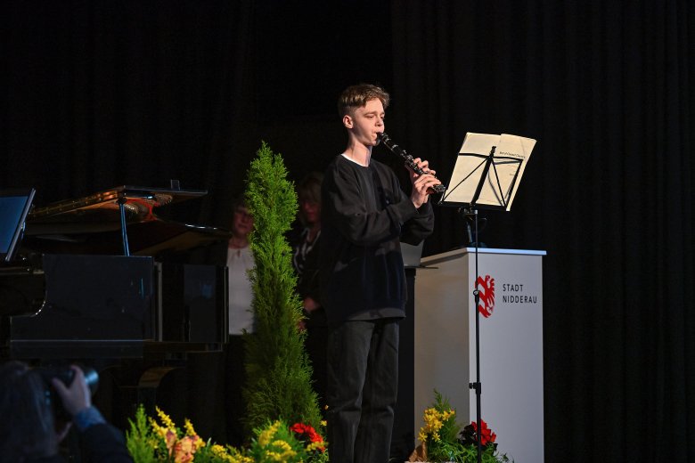 Eine Person stehend auf einer schwarzen Bühne