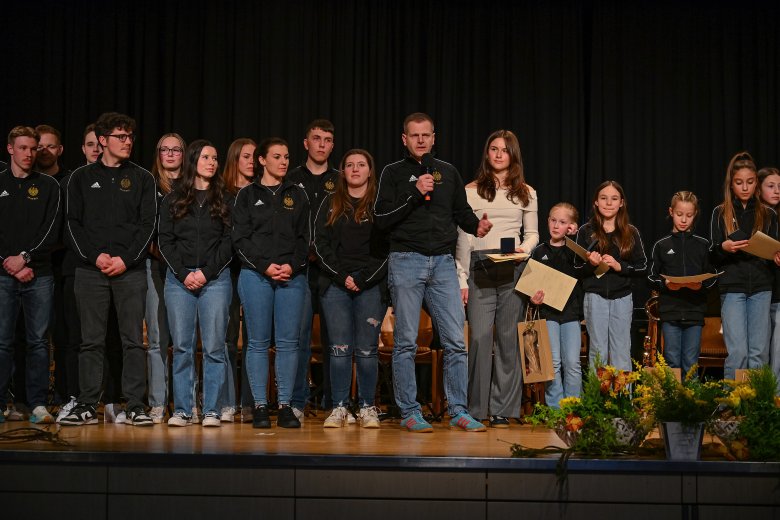 Gruppe von Personen stehend auf einer schwarzen Bühne