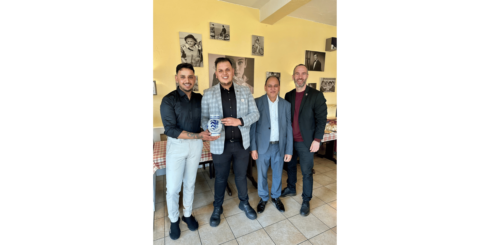 4 Männer stehend, zwei davon halten einen Bembel