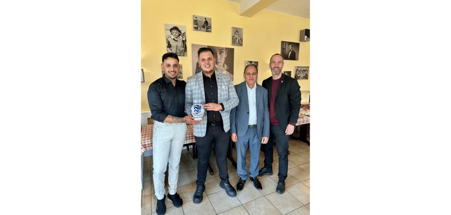 4 Männer stehend, zwei davon halten einen Bembel