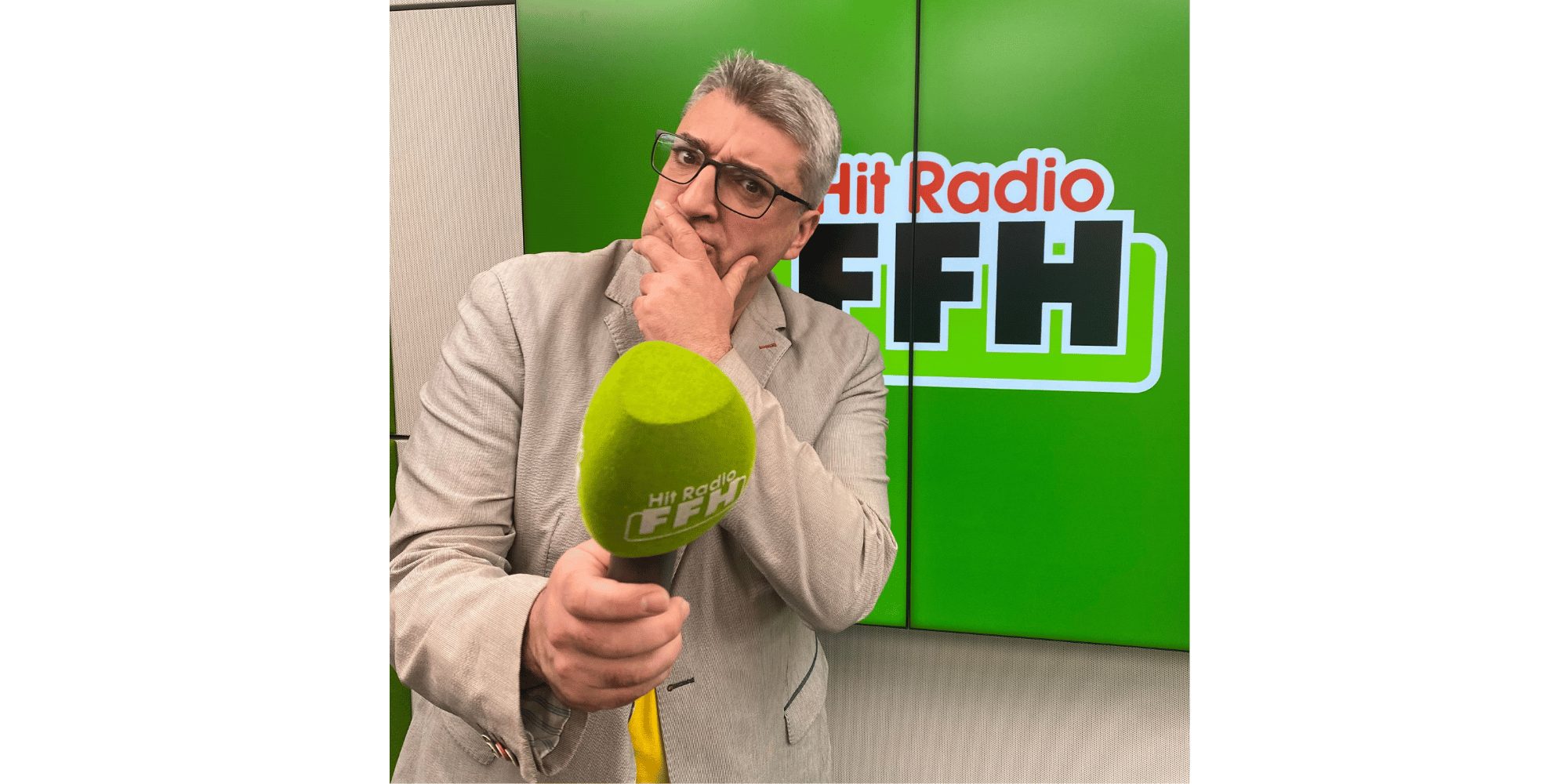 Mann stehend vor grünem Hintergrund