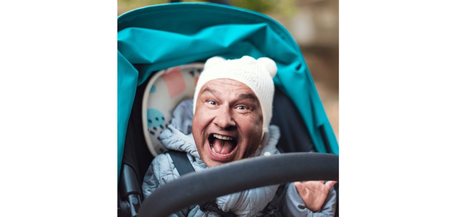 Mann im KInderwagen