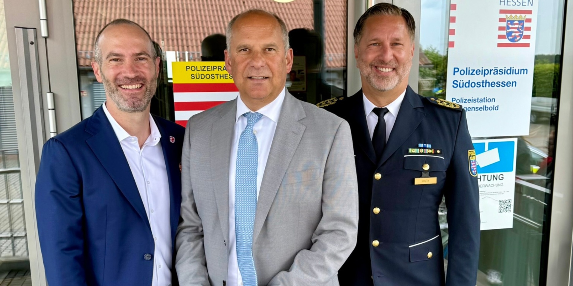 Drei Männer stehen vor einer Glastür