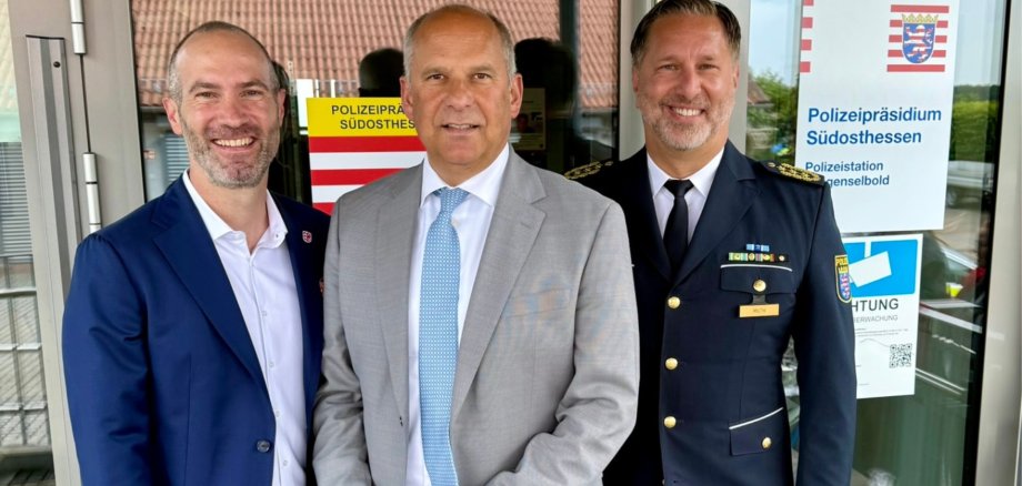 Drei Männer stehen vor einer Glastür