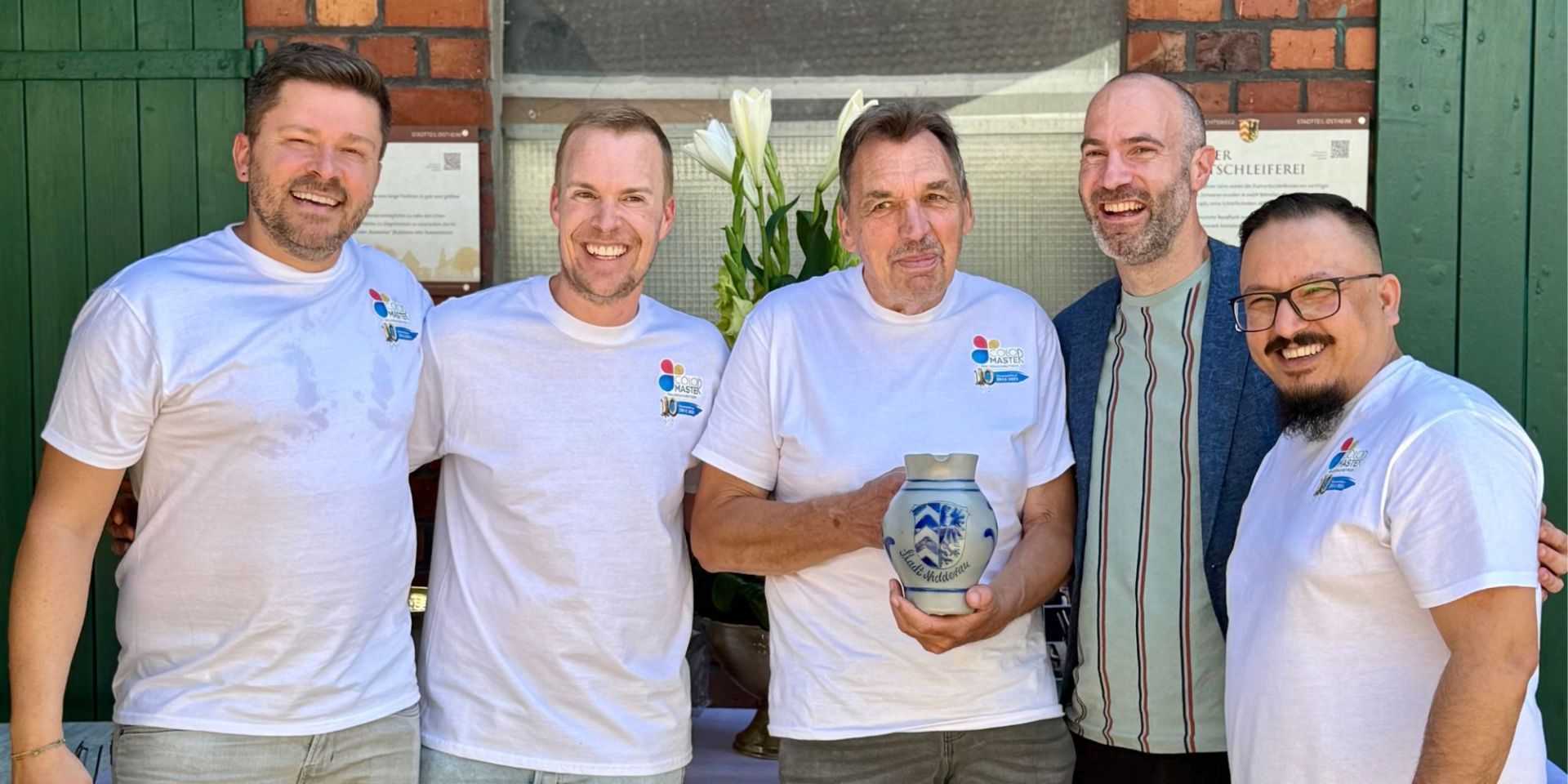 5 Männer stehen vor einem Gebäude