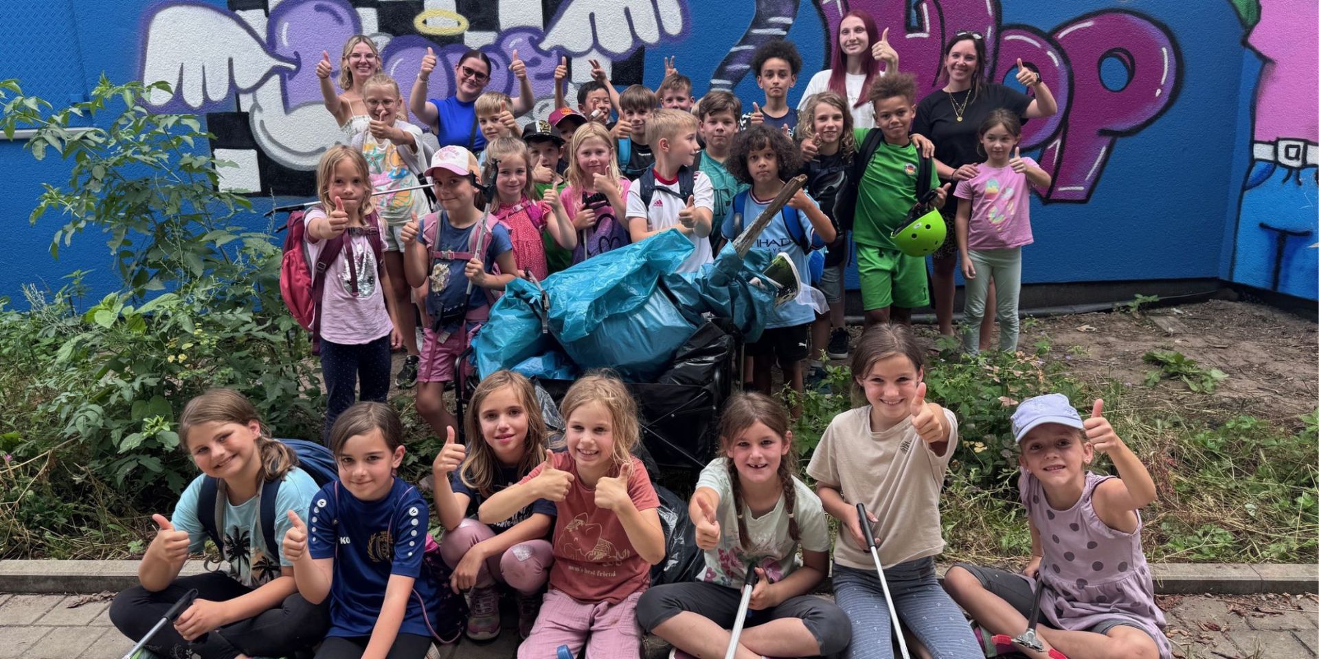Eine Gruppe von Kindern streckt die Daumen in die Höhe